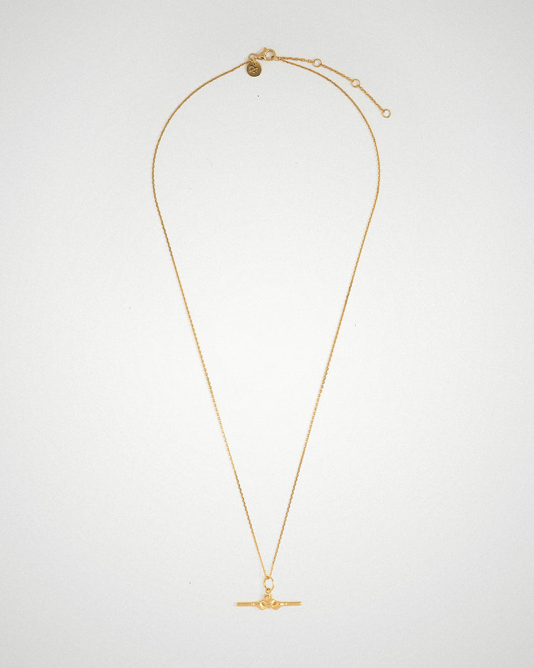 Close-up of the Claddagh detail on an 18k gold-plated bar necklace by Lines & Current