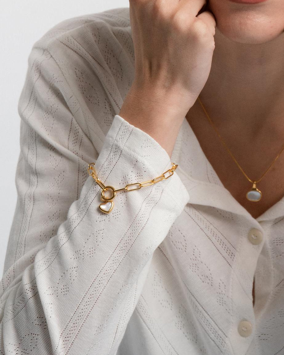 Woman wearing sigrid heart charm on a paperclip chain 