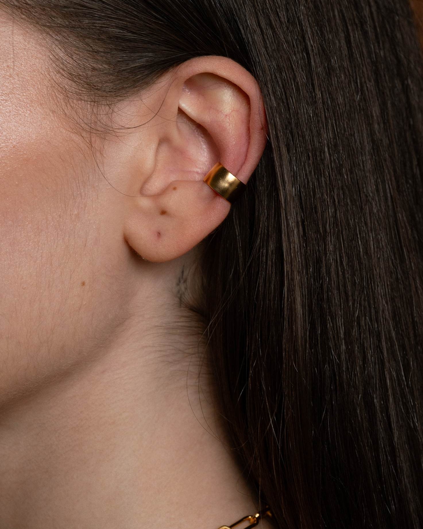 Close-up of an ear wearing a gold ear cuff 