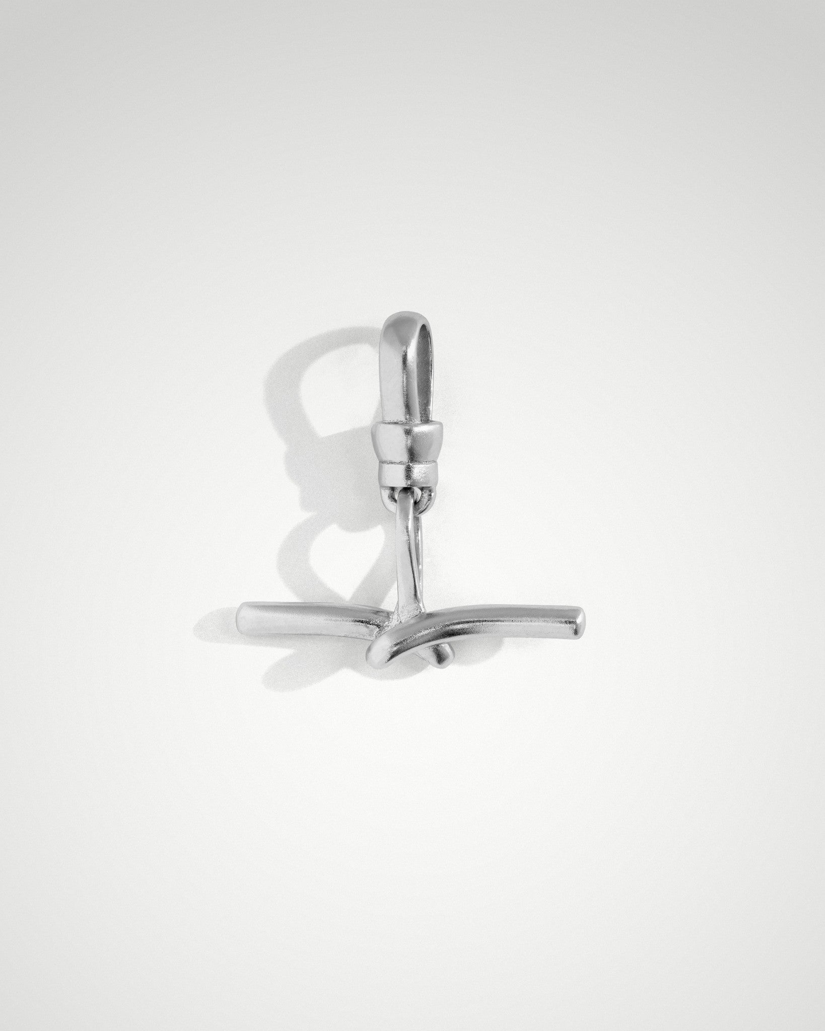 Tabitha T bar charm in unpolished rhodium-plated sterling silver, 20mm x 20mm, with overlapping detail and Albert style bail for chain attachment.