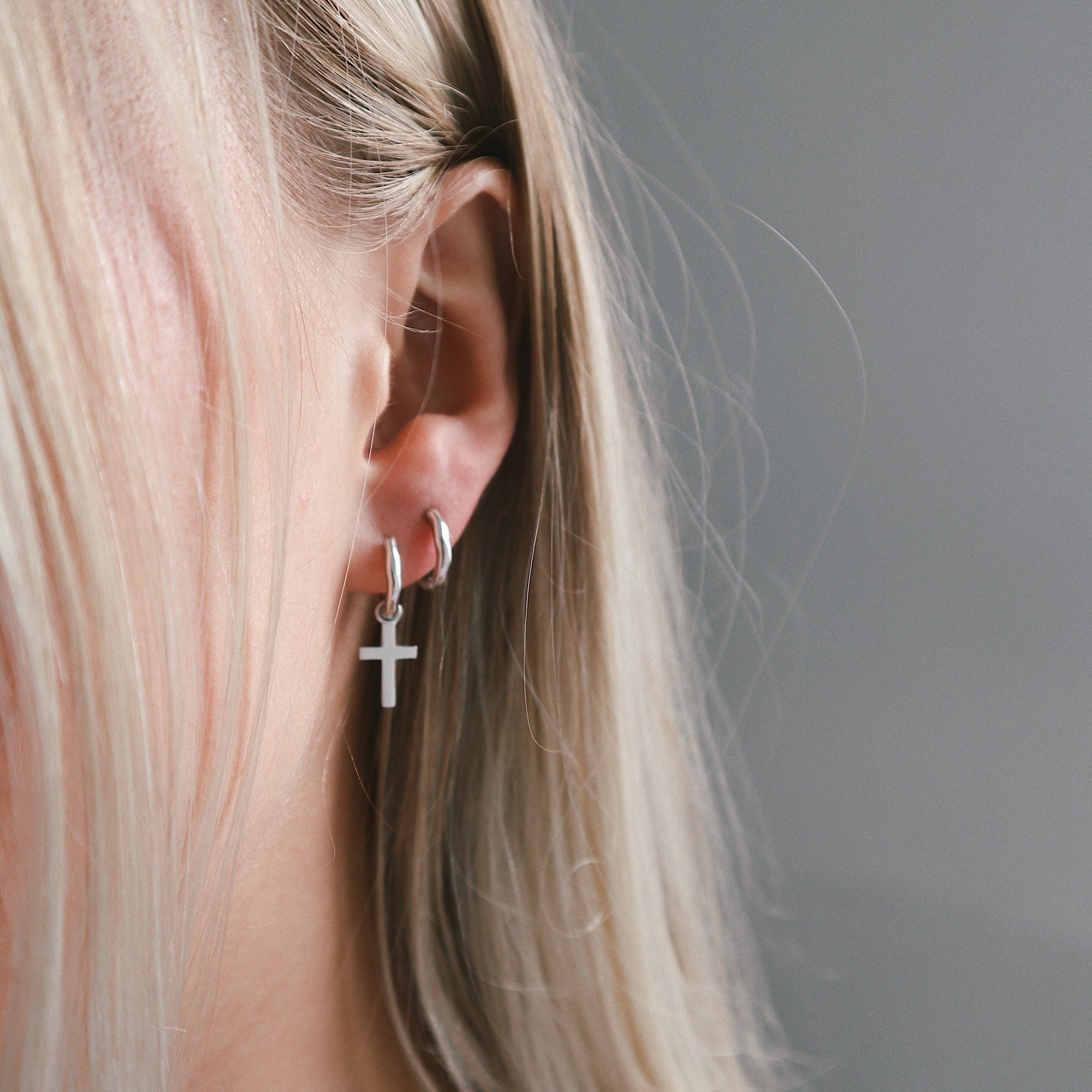 huggie mini hoop earring with cross charm